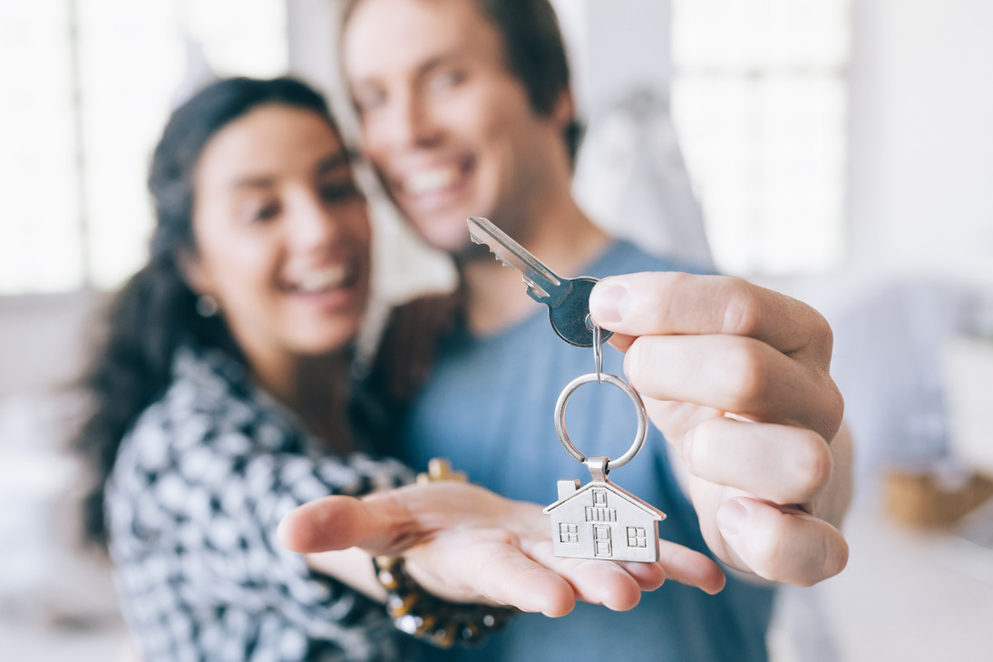 Couple cheerful home owners holding a key